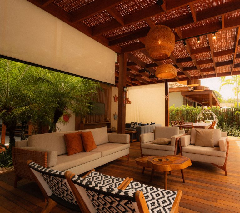 Modern outdoor patio with comfortable lounge furniture beneath a wooden pergola