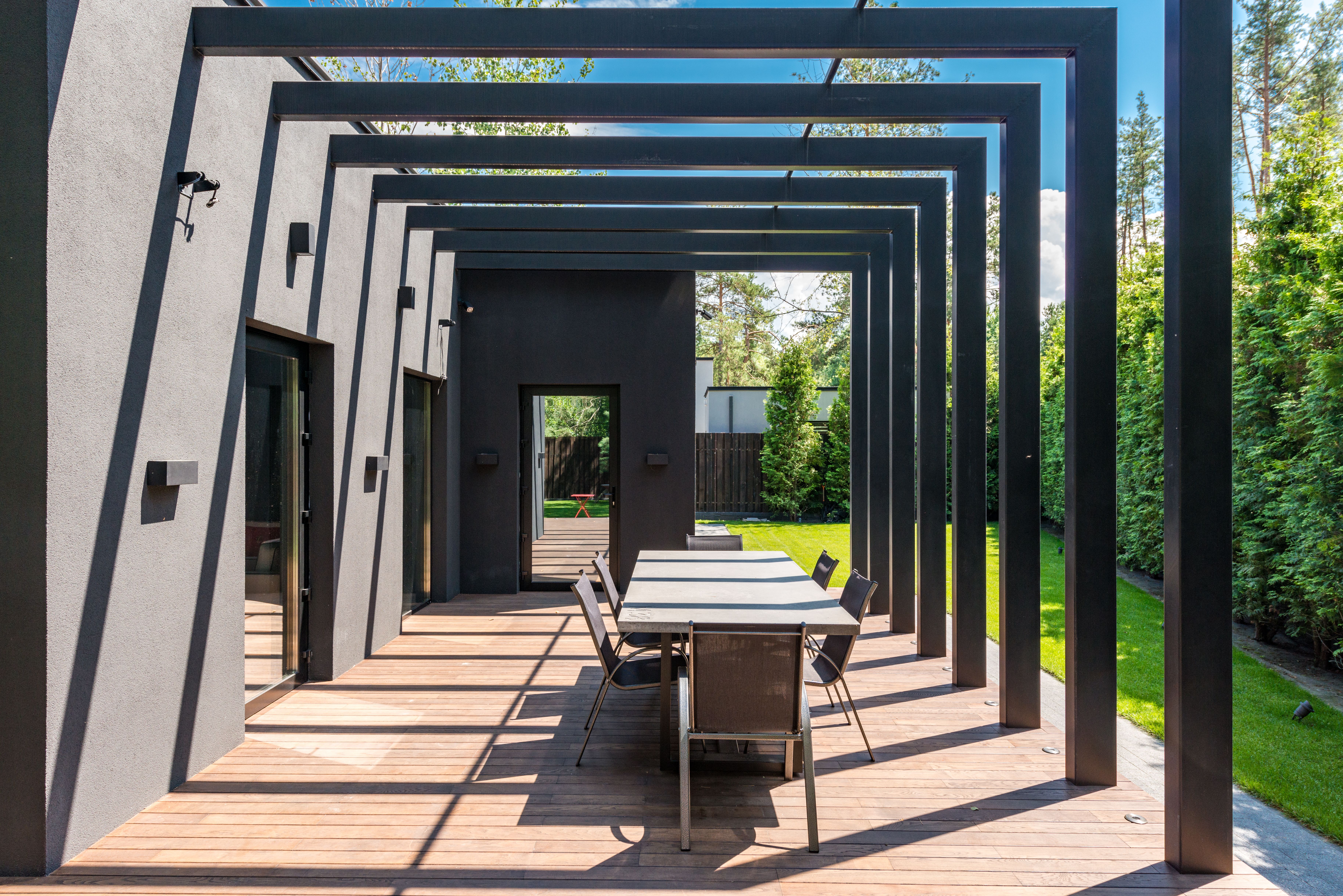 Modern patio dining set sheltered by an elegant pergola