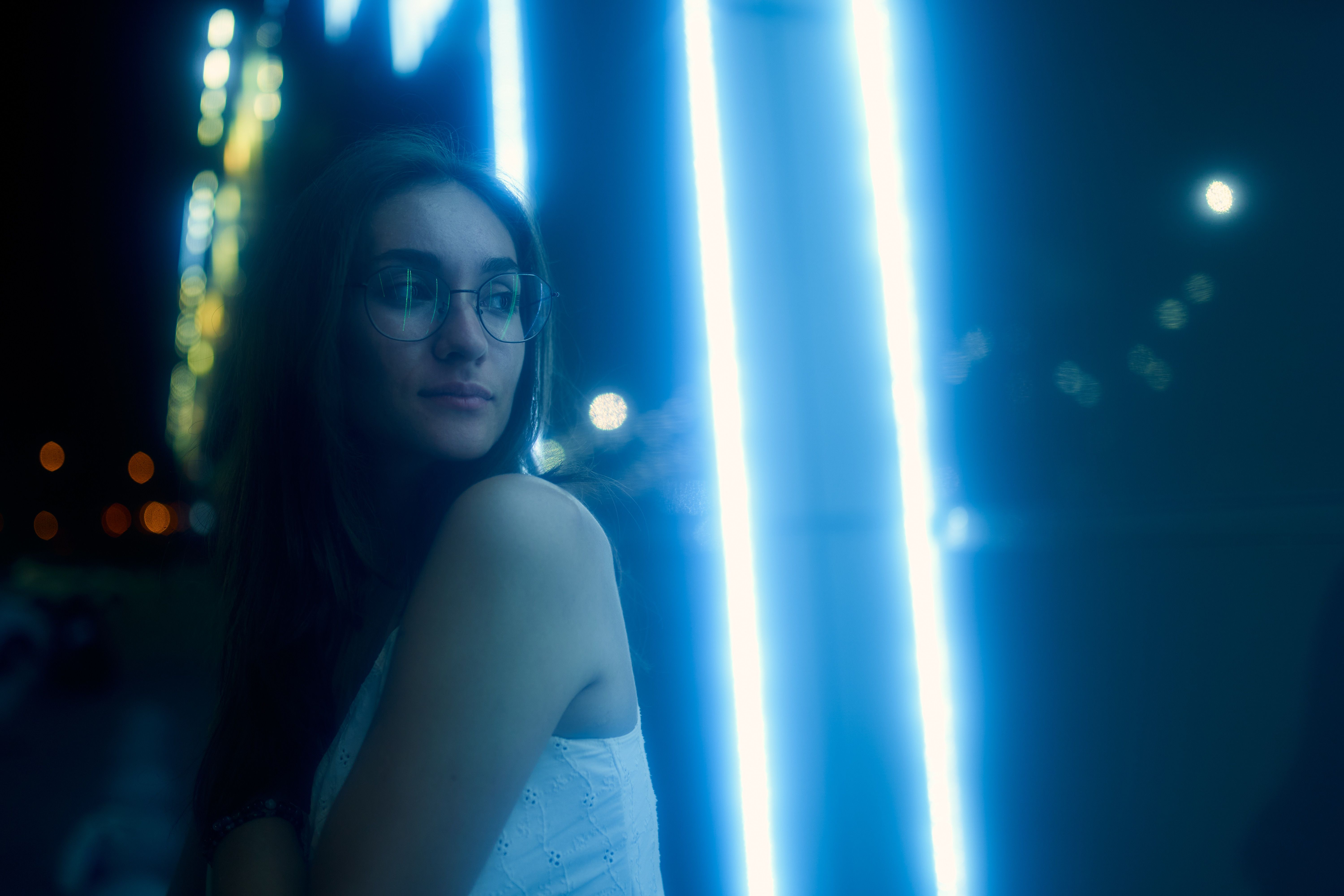 A woman in a city at night looking thoughtful, evoking the personal choices and social perceptions around companionship.