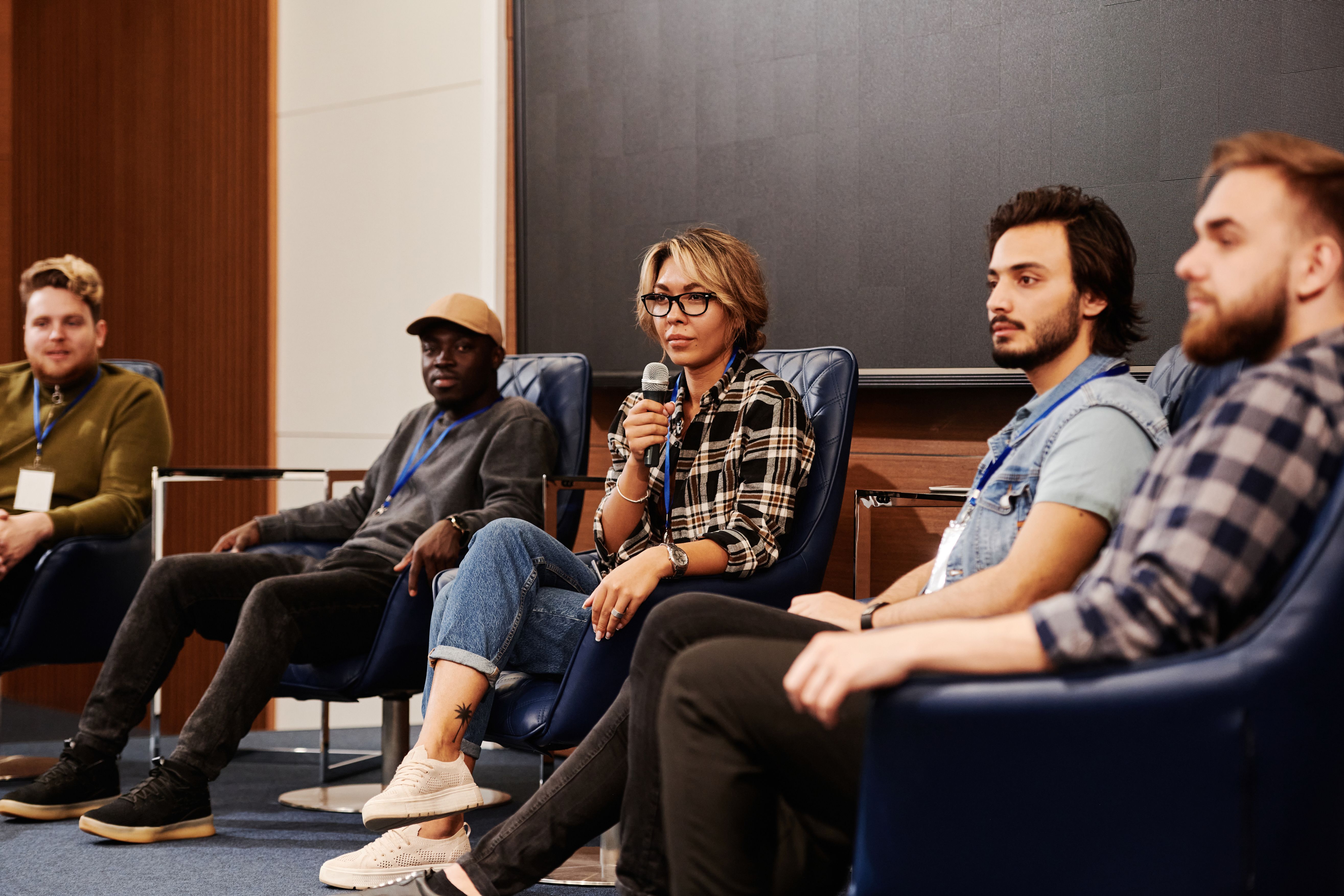 A diverse panel sharing ideas at a public discussion, representing society's evolving conversation about paid companionship.